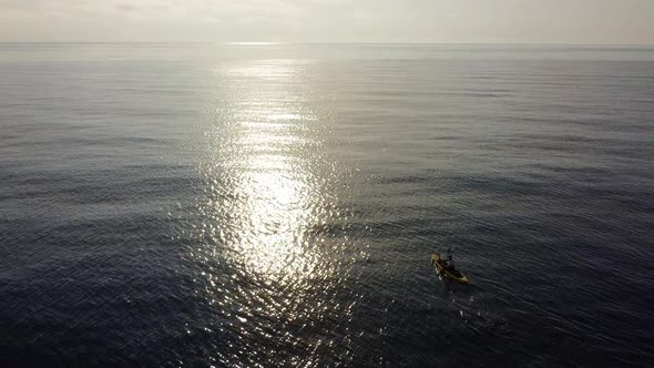 Fisherman trolling in kayak at mediterranean sea aerial drone view in middle of ocean.