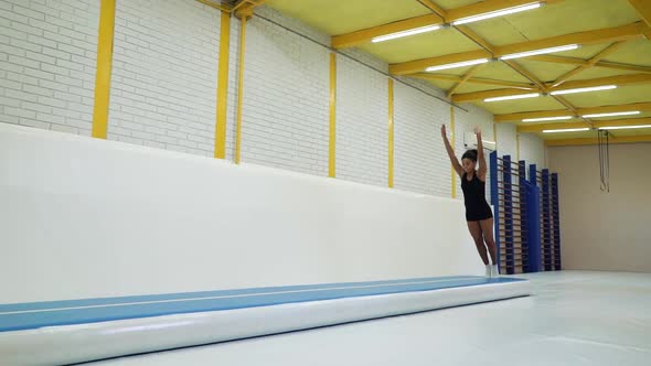 Black woman training in gym and making flips