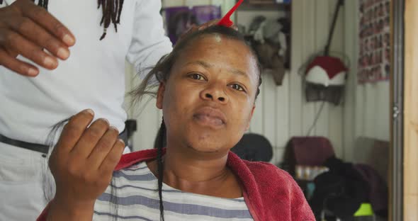 African woman having her hair styled