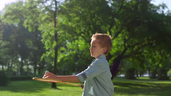 Focused Boy Failed to Hit Shuttlecock on Sunny Day