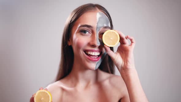 Beautiful Girl Hiding Eyes Behind Lemon Slices 