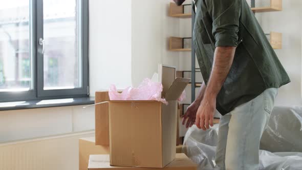 Happy Man with Boxes Moving to New Home