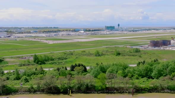 Evergreen Airport Field Of YVR- Vancouver International Airport With A Landing Plane In The Backgrou