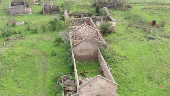 Roofless derelict buildings in an abandoned farm deserted due to rural flight - migration to cities.