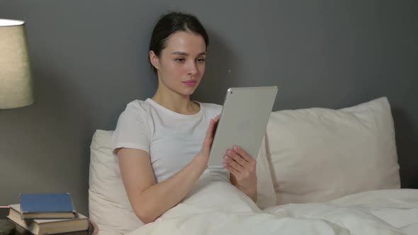 Young Woman Using Tablet in Bed