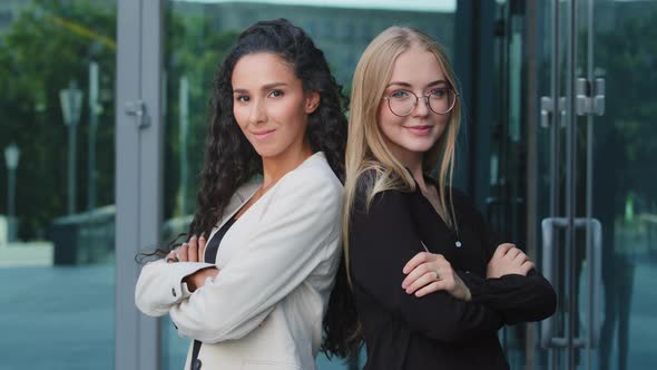 Portrait of Smiling Millennial Young Blonde Woman in Glasses and Millennial Brunette Standing Posing