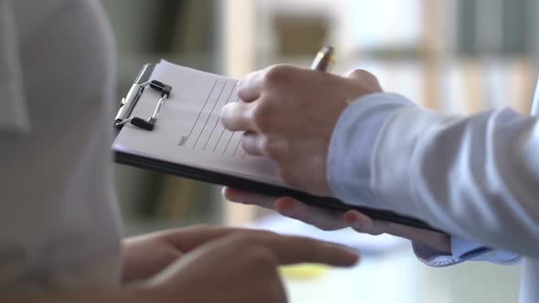 Male Doctor Writing Down Patient Complaints, Stomach Pain, Acid Reflux, Ulcer