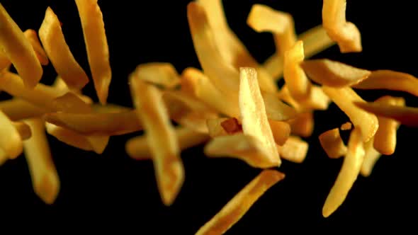 Super Slow Motion French Fries Flying Against a Black Background