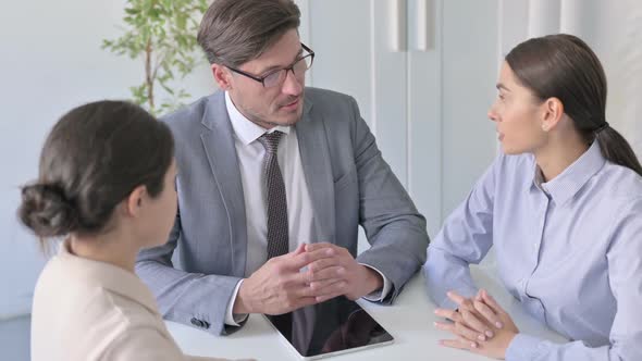 Serious Male and Female Business People having Discussion in Office