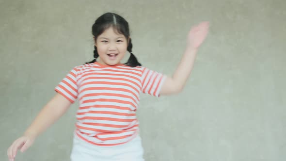 happinss asian female child dance and jump along music on bed. Concept: Music, freedom, happiness