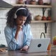 Female Freelancer in Headphones Working From Home on Kitchen and Using Laptop - VideoHive Item for Sale