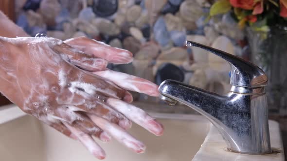 Young Man Washing Hands with Soap Warm Water