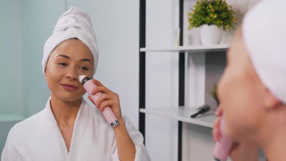 Girl in a Bathrobe Uses a Vacuum Cleaner