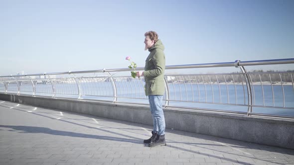 Young Caucasian Chubby Girl Running To Boyfriend Standing with Rose on River Bank and Hugging Him