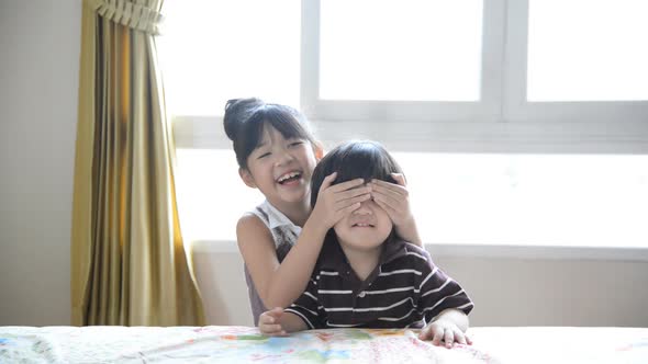 Excited Asian Boy And Girl Play Hide And Seek In Bedroom