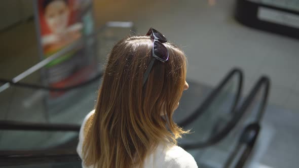  Young, Attractive Woman Going Down the Escalator.