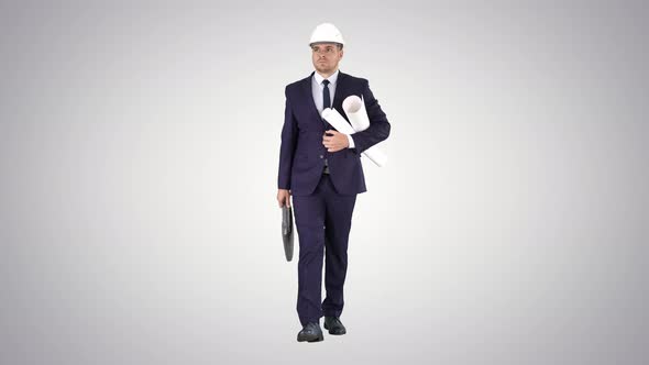 Male Architect in a Suit and Hard Hat Walking with Blueprints and Briefcase on Gradient Background alt