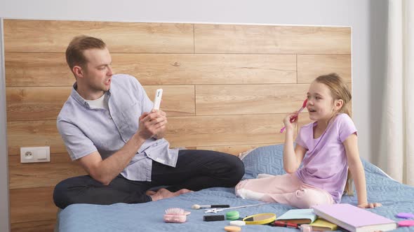 Young Caucasian Trendy Father Take Photo of His Fashionable Daughter Using Cosmetics