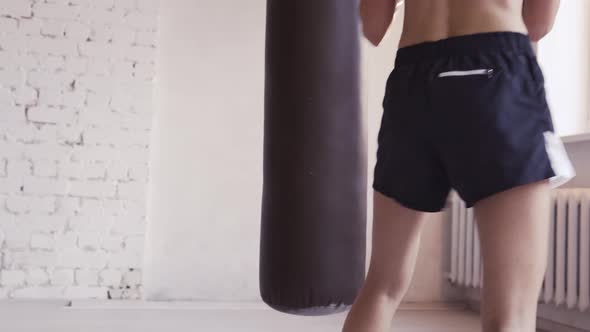 During Training a Cute Kickboxer Girl Took a Break to Rest and Leaned Against a Punching Bag