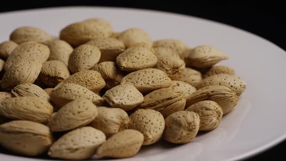 Cinematic, rotating shot of almonds on a white surface 