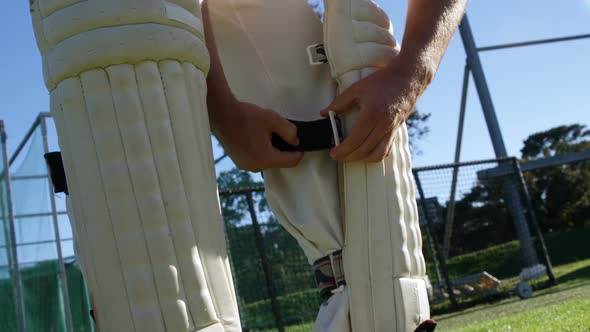 Cricket player tying his batting pads during a practice session