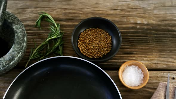 Raw steak, ingredients and pan on wooden table