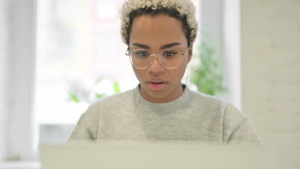 Close Up of African Woman Celebrating Success on Laptop