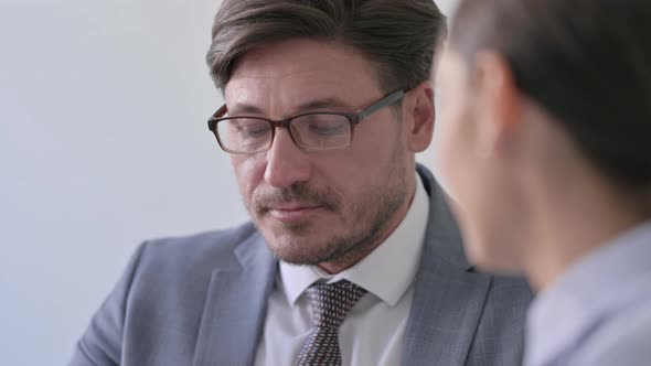 Middle Aged Businessman Talking to Female Colleague