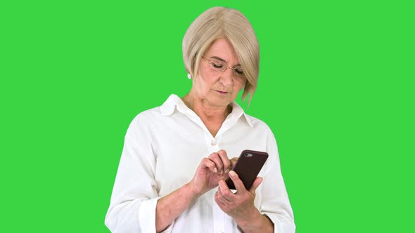 Senior Woman Lady Using Smartphone on a Green Screen Chroma Key