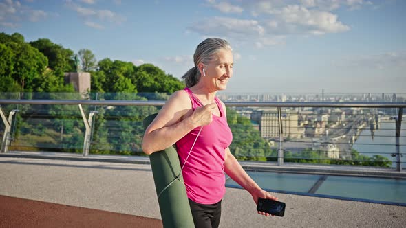 Woman Talks to Friend on Phone Walking on Pedestrian Bridge