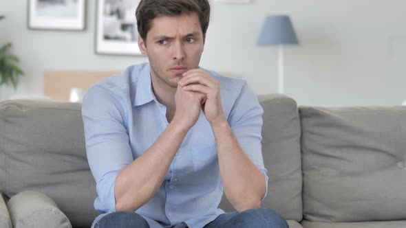 Stressed Handsome Young Man Sitting Tense on Couch