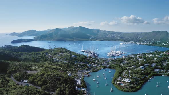 Drone descends to the yachts in bay of the coastal city at Falmouth Harbour in Antigua and Barbuda