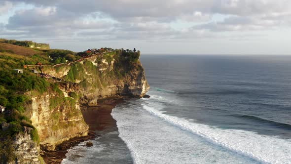 Amazing Aerial View of High Cliffs Above Blue Ocean, Silhouette of Uluwatu Temple on the Cliff Top