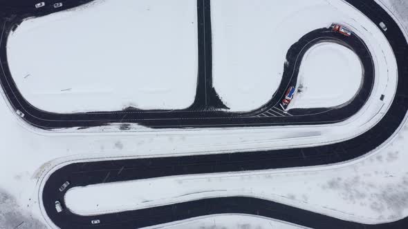 Aerial Fpv View Winter Serpentine Road Infrastructure with Movement Cars at Blizzard