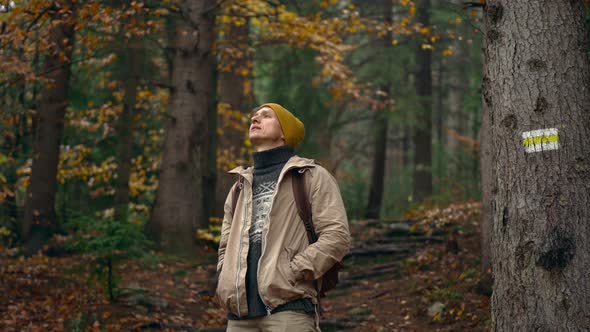 Satisfied Traveler Hipster Stands in Picturesque Place of Wildlife Looks at Autumn Landscape and