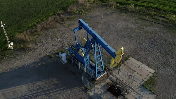 Oil Pumpjack In An Oilfield Working And Pumping Crude Oil For Fossil Fuel With Drilling Rig. drone d