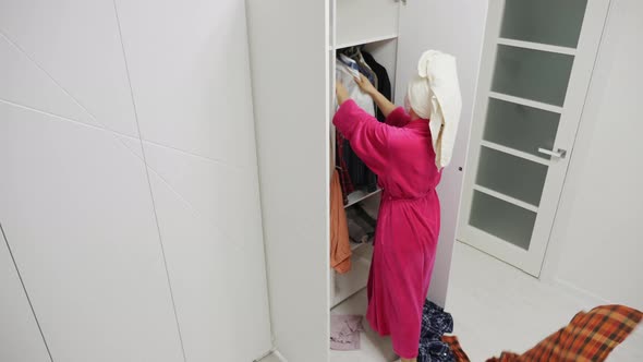 Annoyed Woman Throwing Clothes Out of the Closet