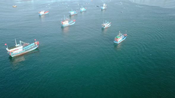 Aerial View of Small Village Shore with Colorful Fishing Boats on Turquoise Ocean.