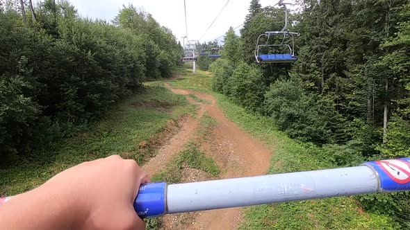 Girl Rides or Climbs on Lift or Cable Car Up Mountain