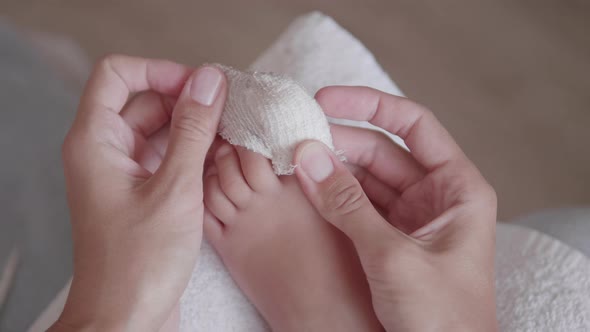 Mother Bandages Her Child's Big Toe