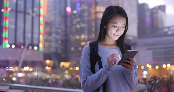 Asian woman use of mobile phone in city at night