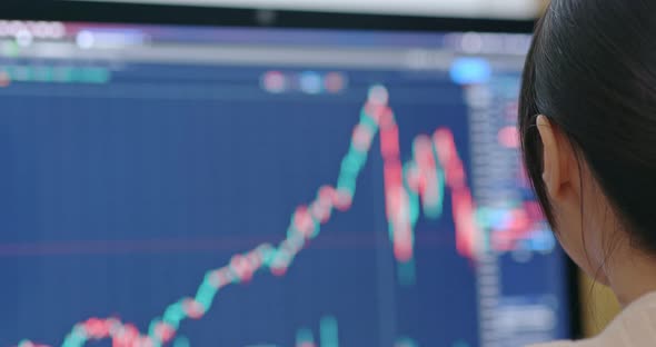 Woman check on stock market data at the screen of computer