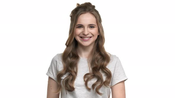 Portrait of Friendly Female with Beautiful Auburn Hair Smiling on Camera and Welcoming with Waving