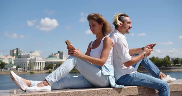 Modern Addictions  a Man and a Woman Sit Buried in Smartphones During a Date