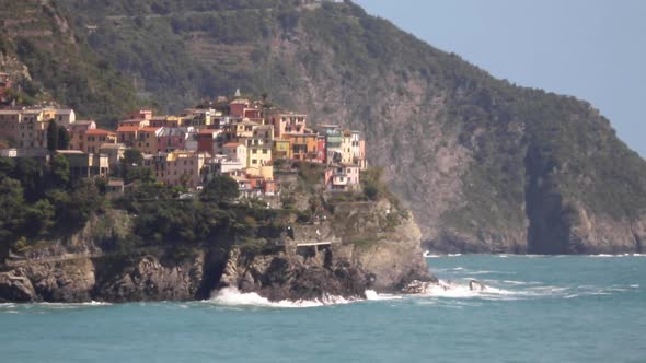 Manarola Cinque Terre Italy Cliffside fishing town on Mediterranean Sea coast with waves crashing ag