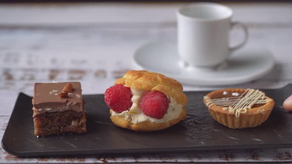 Serving fresh desserts on a black plate, close up