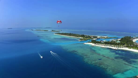 Aerial Shot of south male atoll with paraglider