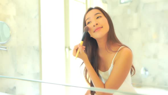 Young asian woman check her face on mirror