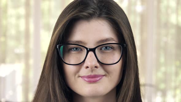 Portrait of a Young Woman in Stylish Glasses Smiling and Looking at the Camera 
