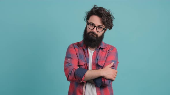 Portrait of a Serious Young Man Standing with His Hands Folded and Nodding